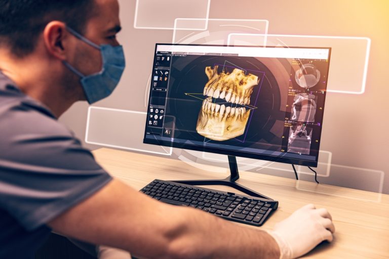 Attentive,Dentist,Examining,An,X-ray,On,Computer,In,Dental,Clinic